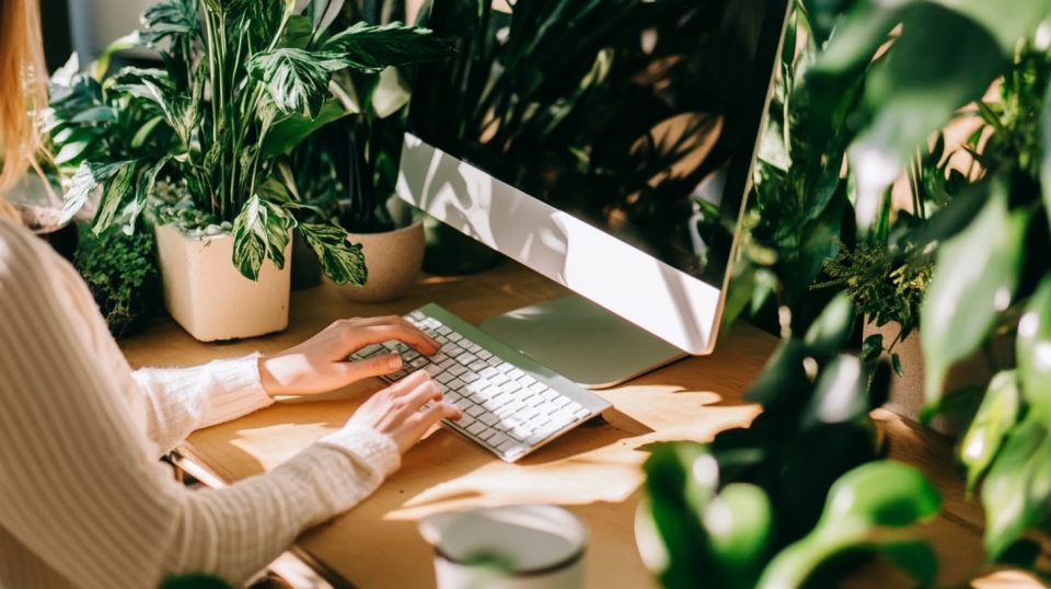 A professional enters information on a computer, their hand hovering over the keyboard while looking satisfied with the process. ai generated