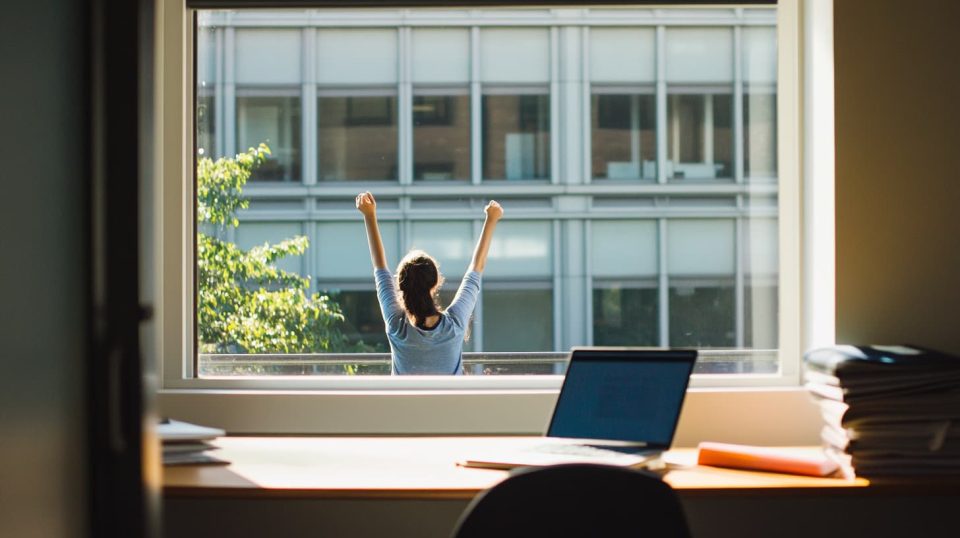 A student stretching by the window during a break. ai generated